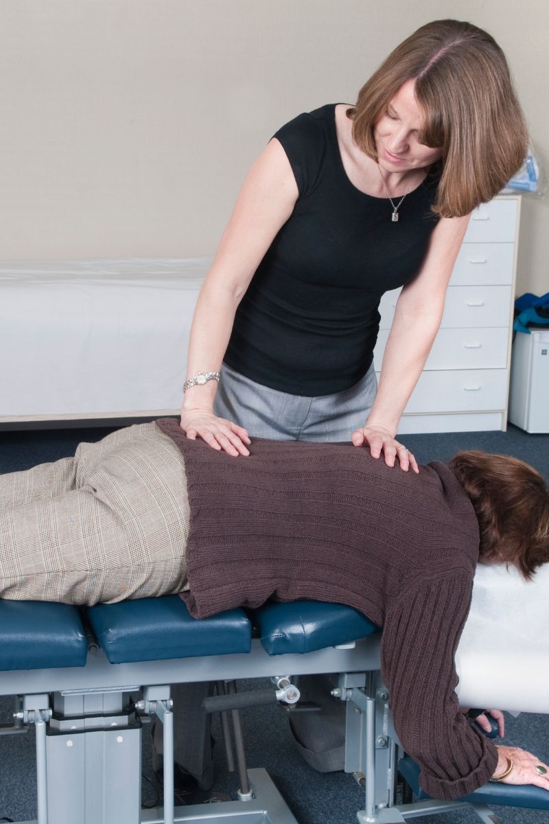 A woman is being assisted by a physiotherapist specializing in workers compensation.