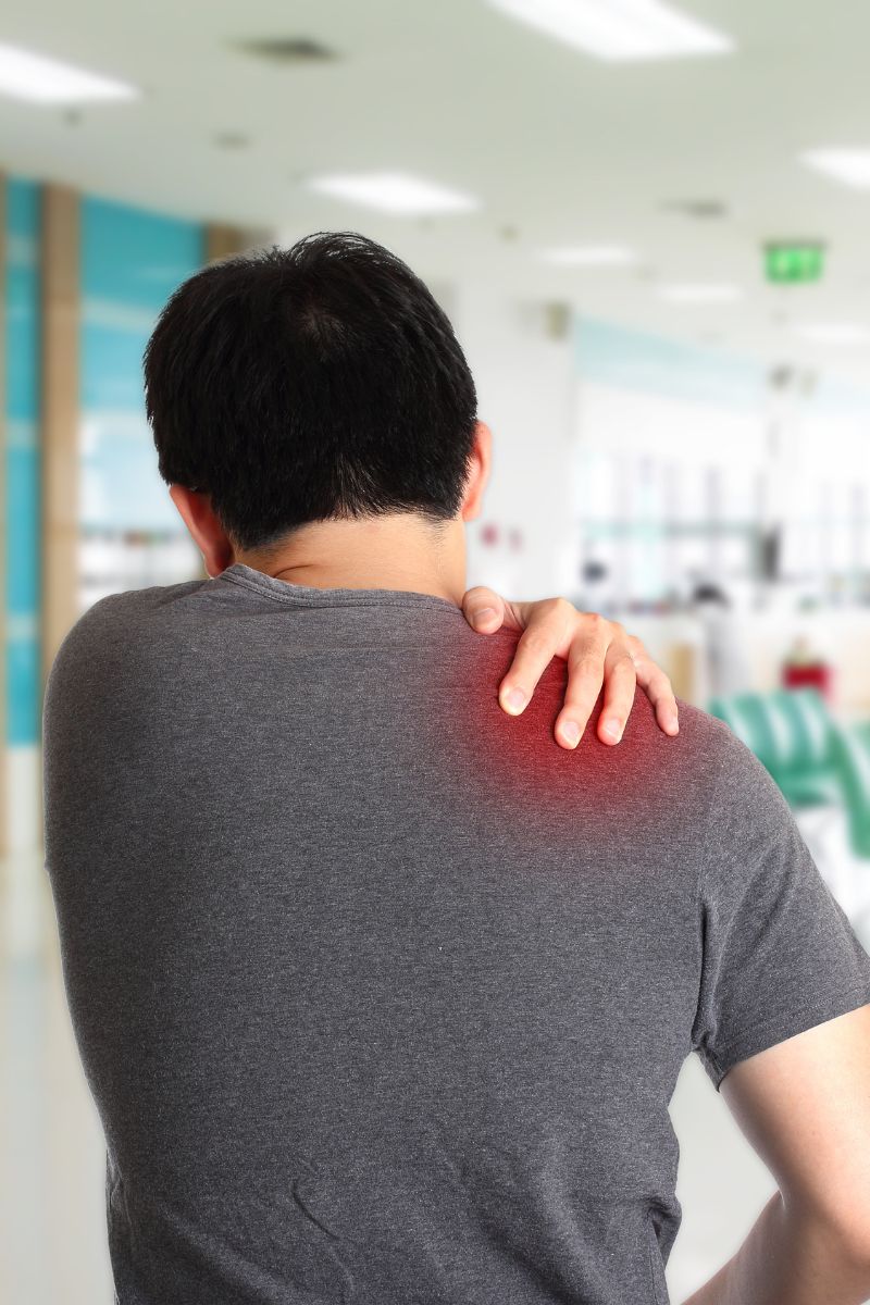 A man with a shoulder pain in a hospital seeking treatment from no-fault or workers compensation doctors.