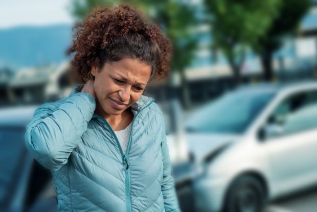 A woman with neck pain seeking treatment from a no-fault doctor after a car accident.