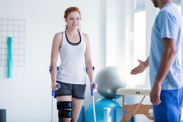 A woman consulting with a physical therapist specialized in workers compensation injuries at a gym.