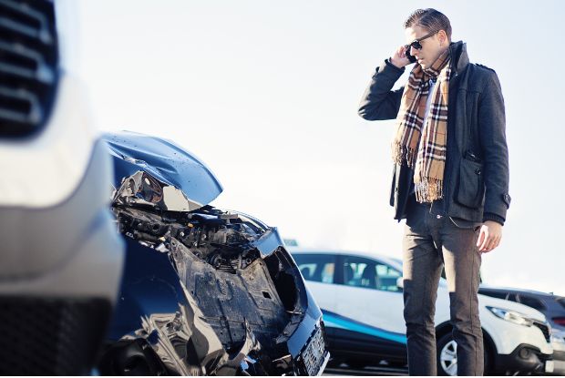 A man discussing car wreck repairs on the phone.