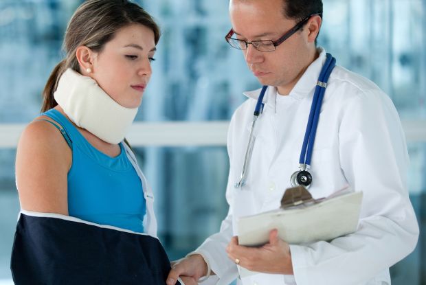 A woman with a neck brace is being examined by a No-Fault doctor.