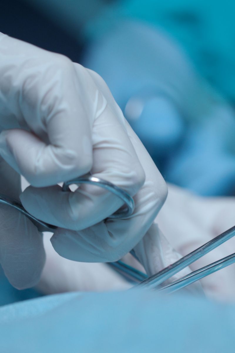 A skilled surgeon's hand expertly holding a pair of scissors for precise wound care.