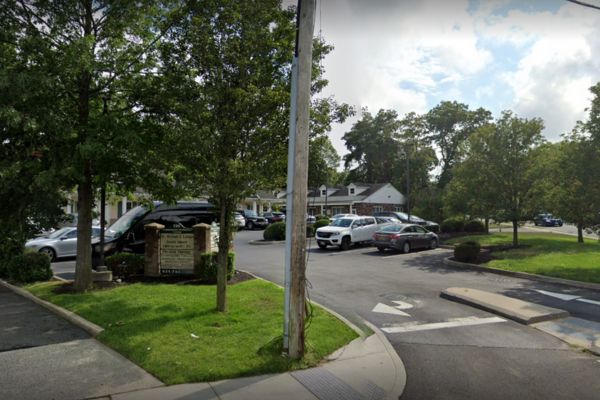 A Google Street View of a parking lot with parked cars in Farmingville, NY.